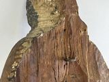 a wooden statue of a man with a hood on