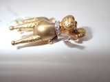 a gold figurine of a dog laying down on a white surface