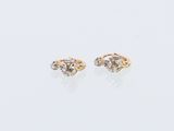 une paire de boucles d'oreilles en diamant sur une surface blanche