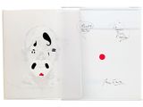 a book with a drawing of a dog and a red dot on it
