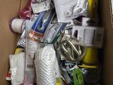 a cardboard box filled with various items that include scissors, tape, scissors, and other items