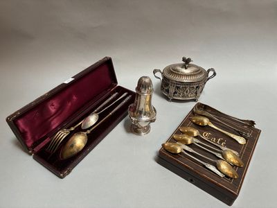 des couverts en argent rangés dans un coffret posé sur une table