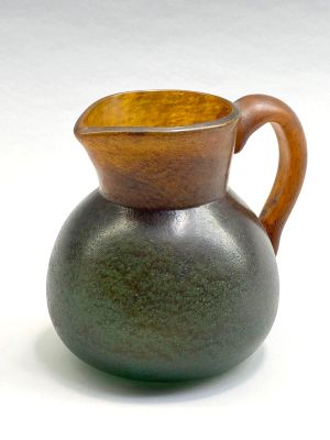un vase vert avec une anse marron sur un fond blanc