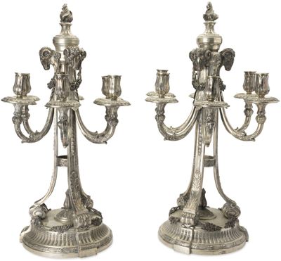 paire de chandeliers plaqués argent avec des bougies sur leurs socles