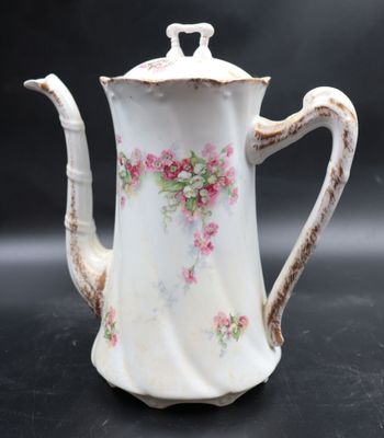 a white tea pot with pink flowers on it