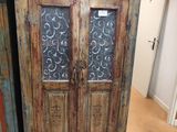 un meuble en bois avec une porte en verre dans une pièce