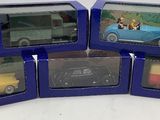 Six petites voitures se trouvent dans une boîte bleue sur une surface blanche.