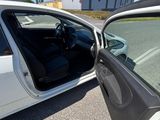 une voiture blanche dont la portière est ouverte, garée sur le bord de la route