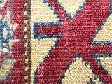a close up of a red and blue rug with a lion on it