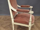 an old chair with a red upholstered seat on a wooden floor