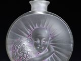 an image of a glass perfume bottle on a black surface