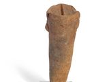 a small piece of pottery on a stand on a white surface