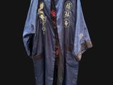 a blue jacket hanging on a hanger on a black wall
