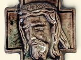 a ceramic cross with a face of jesus on it