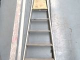a ladder that is sitting on the floor next to a piece of wood