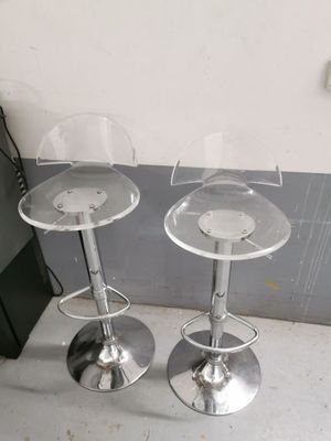 deux tabourets transparents posés côte à côte par terre