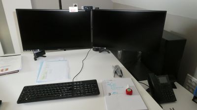 un bureau équipé de deux écrans et d'un clavier