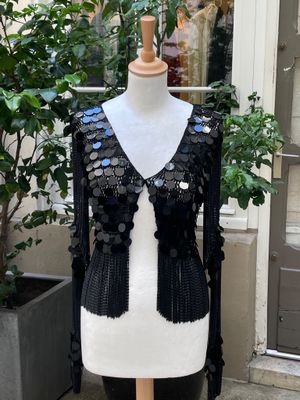 un mannequin recouvert de paillettes devant une vitrine