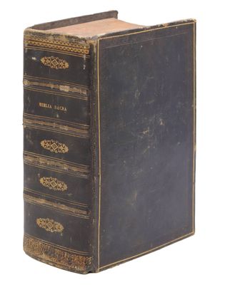 un vieux livre noir orné de dorures sur la couverture