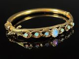 a gold ring with oplites and diamonds