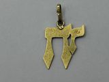 a gold plated pendant with a hebrew symbol on it