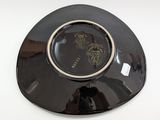 a black plate with a gold rim on a white table