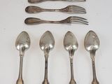 six cuillères et six fourchettes en argent sont alignées sur une surface blanche