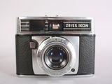 a black and silver camera sitting on a white surface