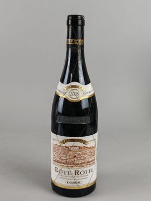 une vieille bouteille de vin posée sur une table à côté d'une bouteille de vin