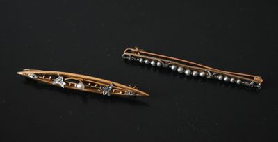 paire d'épingles à cheveux dorées ornées de perles sur fond noir
