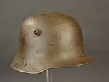 an old helmet on a metal stand on a gray background