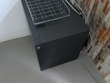 a metal basket sitting on top of a black cabinet