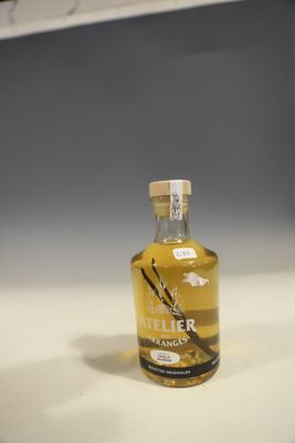 une petite bouteille de sirop de vanille posée sur un plan de travail