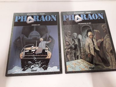 deux livres de Pharaon posés sur une surface blanche, avec un homme dans un bateau