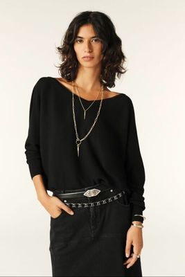 an image of a woman in a black top and black skirt