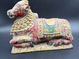 un gros plan sur une figurine représentant un chien posée sur un tapis