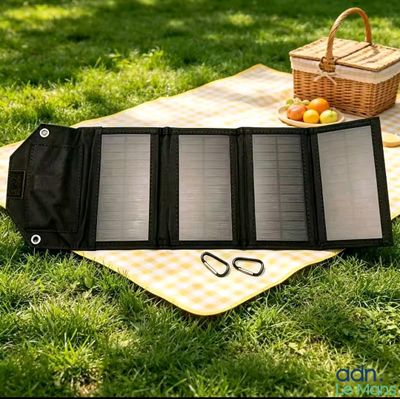 a solar panel sitting on a blanket in the grass