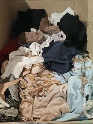 une boîte en carton remplie de vêtements et d'une paire de chaussures