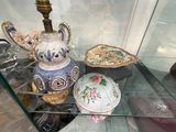 une vitrine en verre sur laquelle sont disposés divers objets décoratifs
