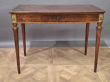 une petite table avec un tiroir, posée sur un parquet