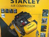 Le carton d'un compresseur d'air Stanley est ouvert et posé par terre.
