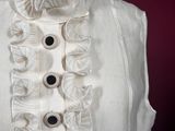 a white shirt with ruffles and buttons on a mannequin
