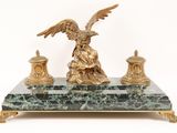 a statue of an eagle sitting on top of a marble table