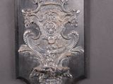 une plaque métallique accrochée au mur sur laquelle figure une horloge