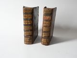 pair of old books on a white surface with a white background