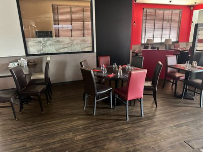 des tables et des chaises dans un restaurant aux murs rouges et au parquet