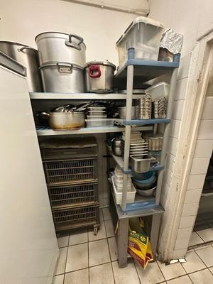 de nombreuses casseroles et poêles sur les étagères de la cuisine