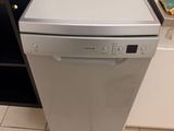 a small silver dishwasher in the corner of a kitchen