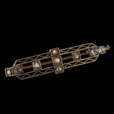 un gros plan d'une broche en or et diamants sur fond noir