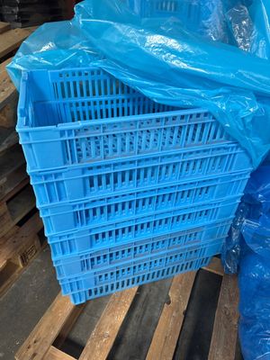 une caisse en plastique bleue posée sur une palette dans un entrepôt